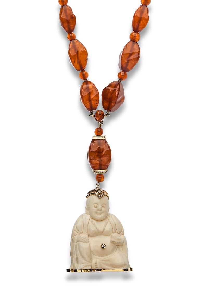 Amber beaded necklace with carved jade Buddha pendant on white background