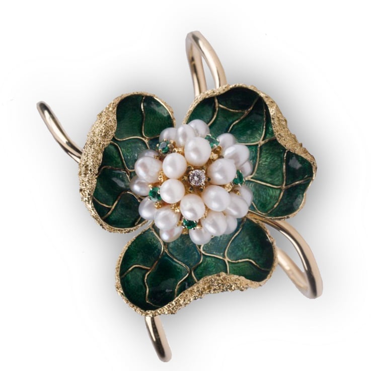 Ornate vintage brooch featuring white pearl cluster flower with dark green enamel leaves and gold filigree detailing