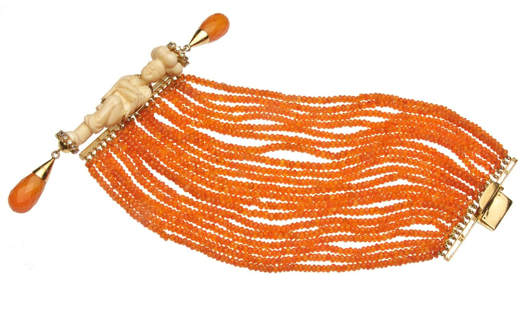 Orange beaded bracelet with ornate gold and amber-colored clasp and decorative teardrop beads