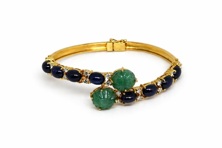Gold bangle bracelet with black and green gemstones and diamond accents