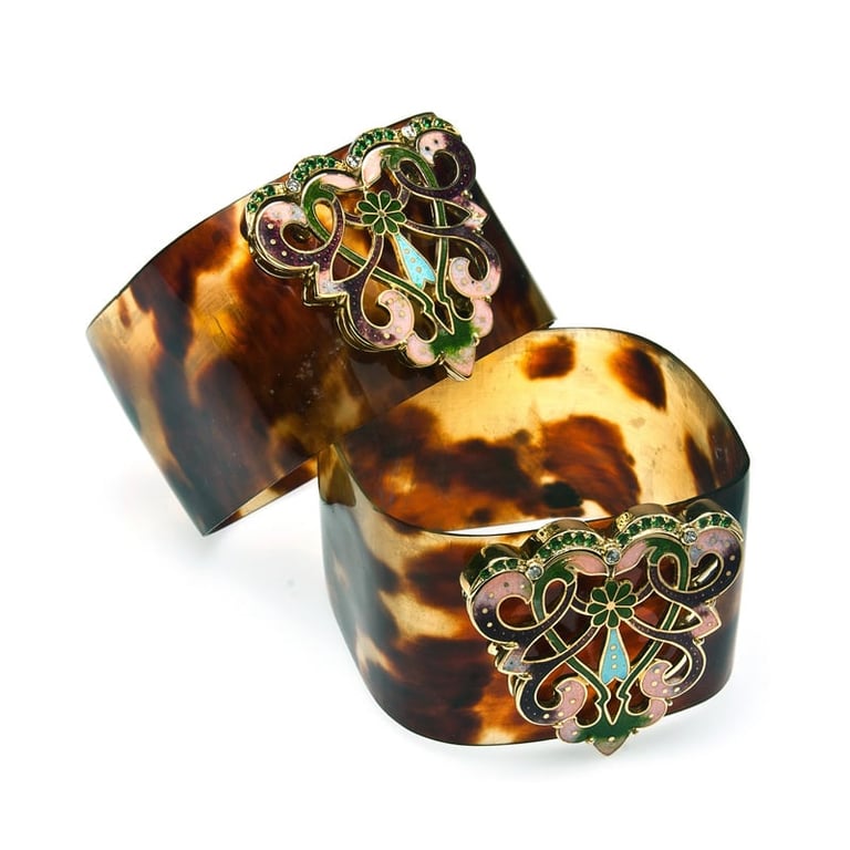 Two tortoiseshell cuff bracelets with ornate brass filigree and turquoise stone accents
