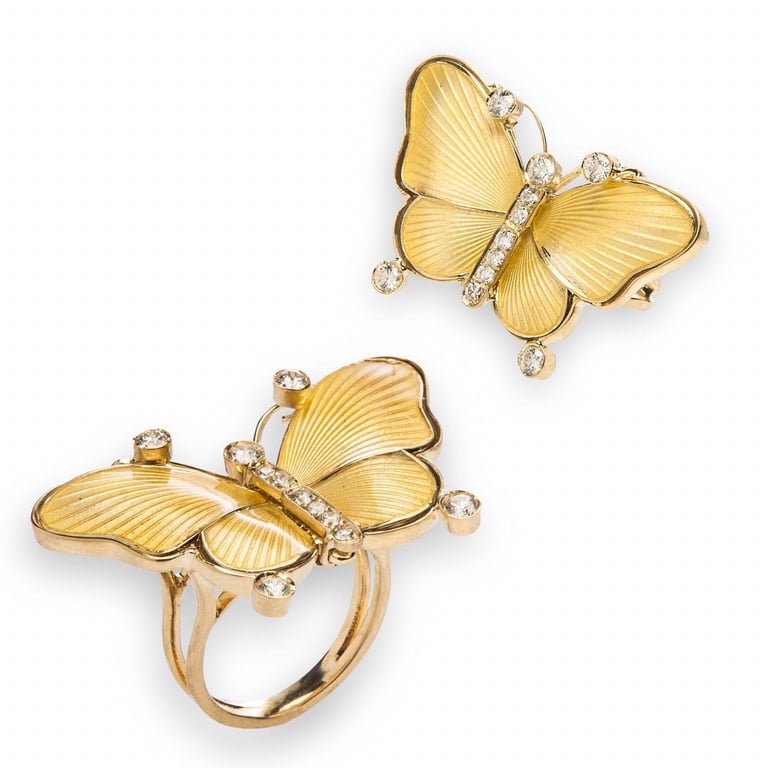 Gold butterfly-shaped jewelry ring and pendant with diamond accents on white background